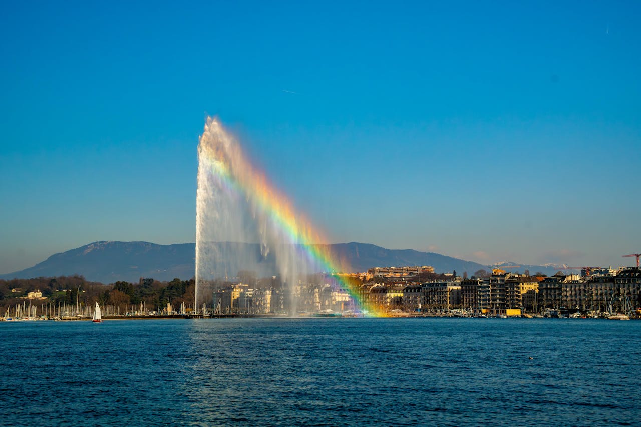 Stunning view of Jet d'Eau fountain with a rainbow over Lake Geneva in Switzerland.